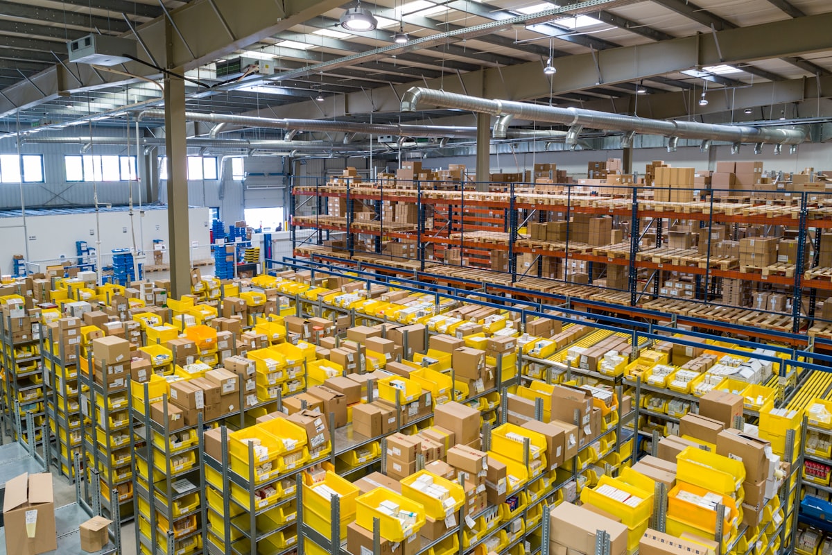 Cardboard shipping packages stacked on wooden pallets in a fulfillment distribution warehouse