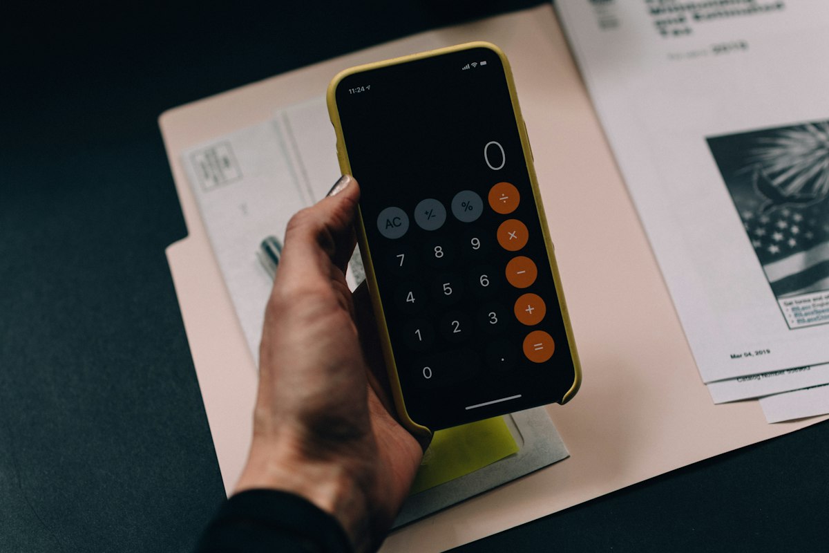 Financial documents and calculator on office desk for Form W-4 payroll tax withholding analysis