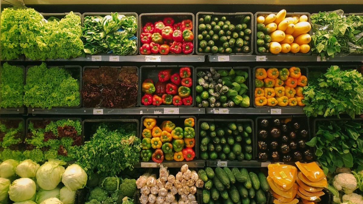 Supermarket grocery shopping cart with fresh produce and pantry staples